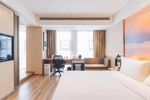 a hotel room with a large bed and a desk at Atour Hotel (Yixing Huankeyuan) in Wuxi