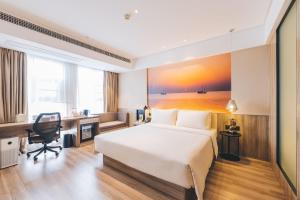 a hotel room with a bed and a desk at Atour Hotel (Yixing Huankeyuan) in Wuxi