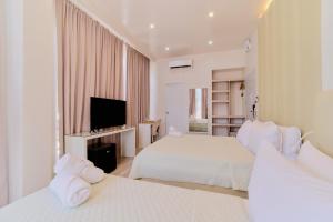 a hotel room with two beds and a television at Pitstop Mango Grove Retreat in Guimaras +21 photos