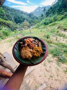 a person holding a plate of food on a mountain at Clay house in Kurukohogama +1 photo