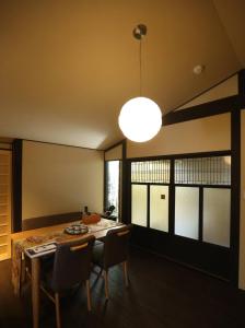 a dining room with a table and chairs and a light at Machiya Minami Omiya in Kyoto