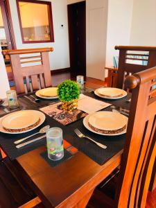 a wooden table with plates and a plant on it at The Signature Suites at Cinnamon life Apartment in Colombo