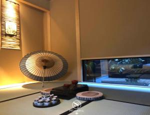 a room with a table with a fan and a television at Machiya Minami Omiya in Kyoto
