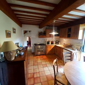 a kitchen with wooden cabinets and a table with a lamp at Charensol in Saint-Sauveur-de-Montagut