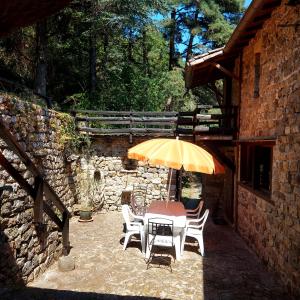 a table and chairs with an umbrella on a patio at Charensol in Saint-Sauveur-de-Montagut