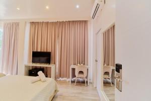 a bedroom with a bed and a desk and a television at Pitstop Mango Grove Retreat in Guimaras