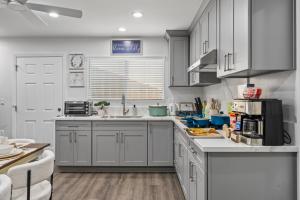 a kitchen with white cabinets and a counter top at Entire Private Home with Yard, King Bed, Prime Location, 3 Bedrooms 3 Bathrooms, Available Now in San Diego