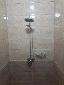a shower with a shower head in a bathroom at Rancho Otel Almaty in Qaskeleng +26 photos