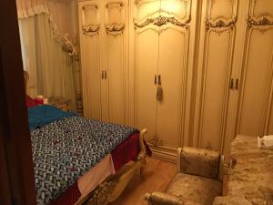 a bedroom with a bed and a dresser and a chair at New Maadi Apartment in Cairo