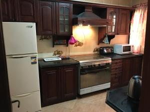 a kitchen with wooden cabinets and a white refrigerator at New Maadi Apartment in Cairo