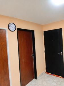 a room with two doors and a clock on the wall at Apartamento Patagonia in Puerto San Julián