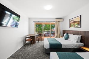 a hotel room with two beds and a table at Sundowner Hotel Motel in Caboolture +84 photos
