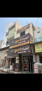 a store front of a building with signs on it at Guru hotel in Sūratgarh