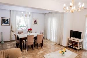 a dining room with a table and chairs and a television at Anastasia in Veria