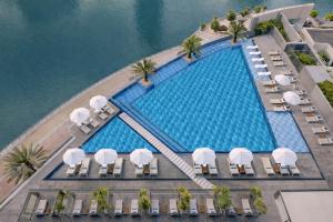 an overhead view of a swimming pool with chairs and umbrellas at InterContinental Dubai Marina by IHG in Dubai
