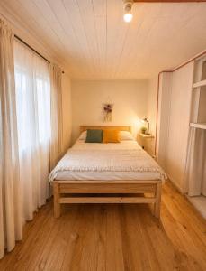 a bedroom with a large bed with a wooden floor at Hostal Casa Trancura in Pucón