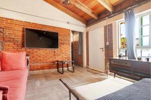 a living room with a brick wall with a flat screen tv at Onenki in Hacienda Ojo de Agua