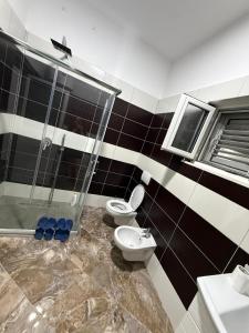 a bathroom with two toilets and a shower at Vila Muhadri in Kamëz