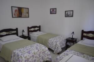 a room with two beds and two tables with lamps at Unibarão Hotel -Próximo as Universidades Unicamp-Puc-Hospitais -Bancos-Restaurantes-Praça Capital -Shopping Dom Pedro - Expo dom pedro-Ceasa in Campinas