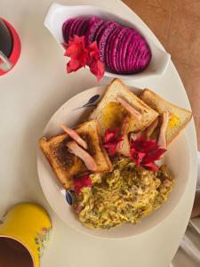 a plate of breakfast food with toast and scrambled eggs at Mansion Sublime in Chitré +19 photos