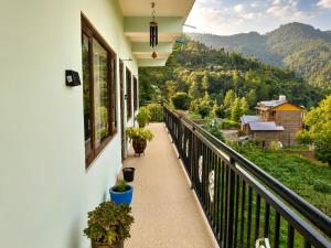 a balcony of a house with potted plants on it at Whispering Meadows Luxury 3BHK Villa in Shimla