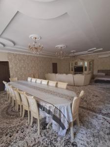 a large dining room with a long table and chairs at Rancho Otel Almaty in Qaskeleng