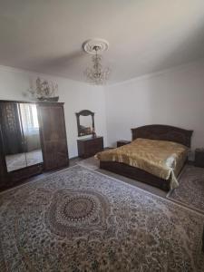 a bedroom with a bed and a large rug at Rancho Otel Almaty in Qaskeleng