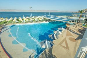 an overhead view of a swimming pool with umbrellas and the ocean at Gai Beach Hotel in Tiberias