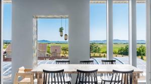 a dining room with a table and chairs and windows at Ganghwa imspa Pension in Incheon