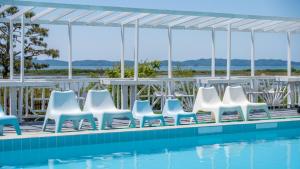 a row of chairs next to a swimming pool at Ganghwa imspa Pension in Incheon
