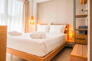 a bedroom with a large white bed with towels on it at Ocean Private Villas - Pefkochori Halkidiki in Pefkochori +101 photos