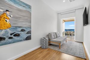 a living room with a painting and a chair at Sunset Sands on Esplanade By Host Solutions in West Beach