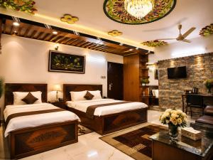 a bedroom with two beds and a living room at Star International Rajshahi - Near Aam chattar in Rājshāhi