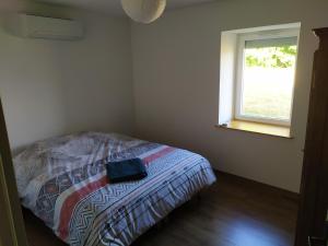 a bed in a room with a window at Meublé Climatisé 75 M2 in Souvans