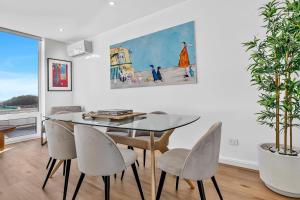 a dining room with a glass table and chairs at Sunset Sands on Esplanade By Host Solutions in West Beach +18 photos