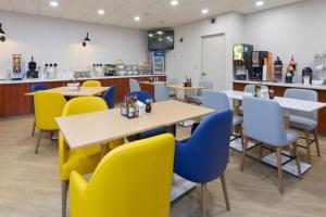 a restaurant with yellow and blue chairs and tables at Comfort Suites Springfield-Eugene in Springfield