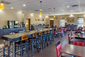 a restaurant with tables and chairs and a bar at Comfort Inn Fort Mill Amusement Park at Carowinds Blvd in Fort Mill