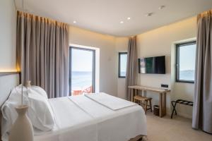 a hotel room with a bed and a view of the ocean at The Palms Kos in Kos