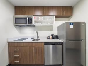 a kitchen with a stainless steel refrigerator and a sink at MainStay Suites Chambersburg in Chambersburg