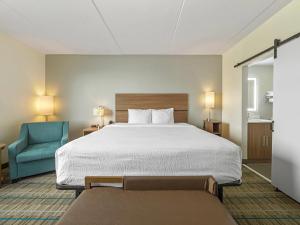 a hotel room with a bed and a blue chair at MainStay Suites Chambersburg in Chambersburg
