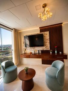a living room with two chairs and a flat screen tv at Tarija Premium Stay Apartamento Premium in Tarija