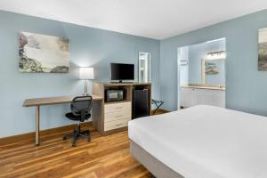 a hotel room with a bed and a desk with a computer at Quality Inn in Barbourville