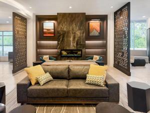 a living room with a couch and a fireplace at Cambria Hotel Jacksonville in Jacksonville