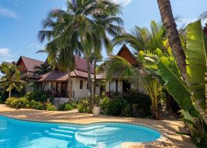 a house with a swimming pool and palm trees at Chaweng Bliss Bungalow in Chaweng