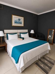 a bedroom with a large bed with blue and white sheets at 42 On Canterbury in Durban