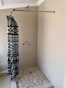a shower with a black and white shower curtain at 42 On Canterbury in Durban +23 photos