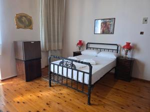 a bedroom with a bed and a wooden floor at Arhodico Simou mansion in Kambos