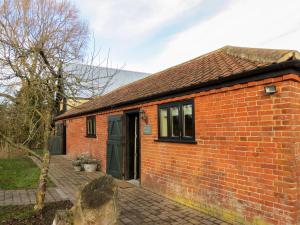 a red brick house with a black door at Appletree Cottage Fressingfield in Fressingfield