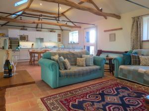ein Wohnzimmer mit 2 Sofas und einer Küche in der Unterkunft Appletree Cottage Fressingfield in Fressingfield