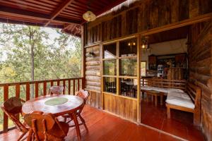 a room with a table and chairs on a deck at Villa Verde in Perquín